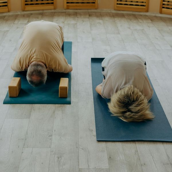 Group of women practicing yoga together in a sunlit room.